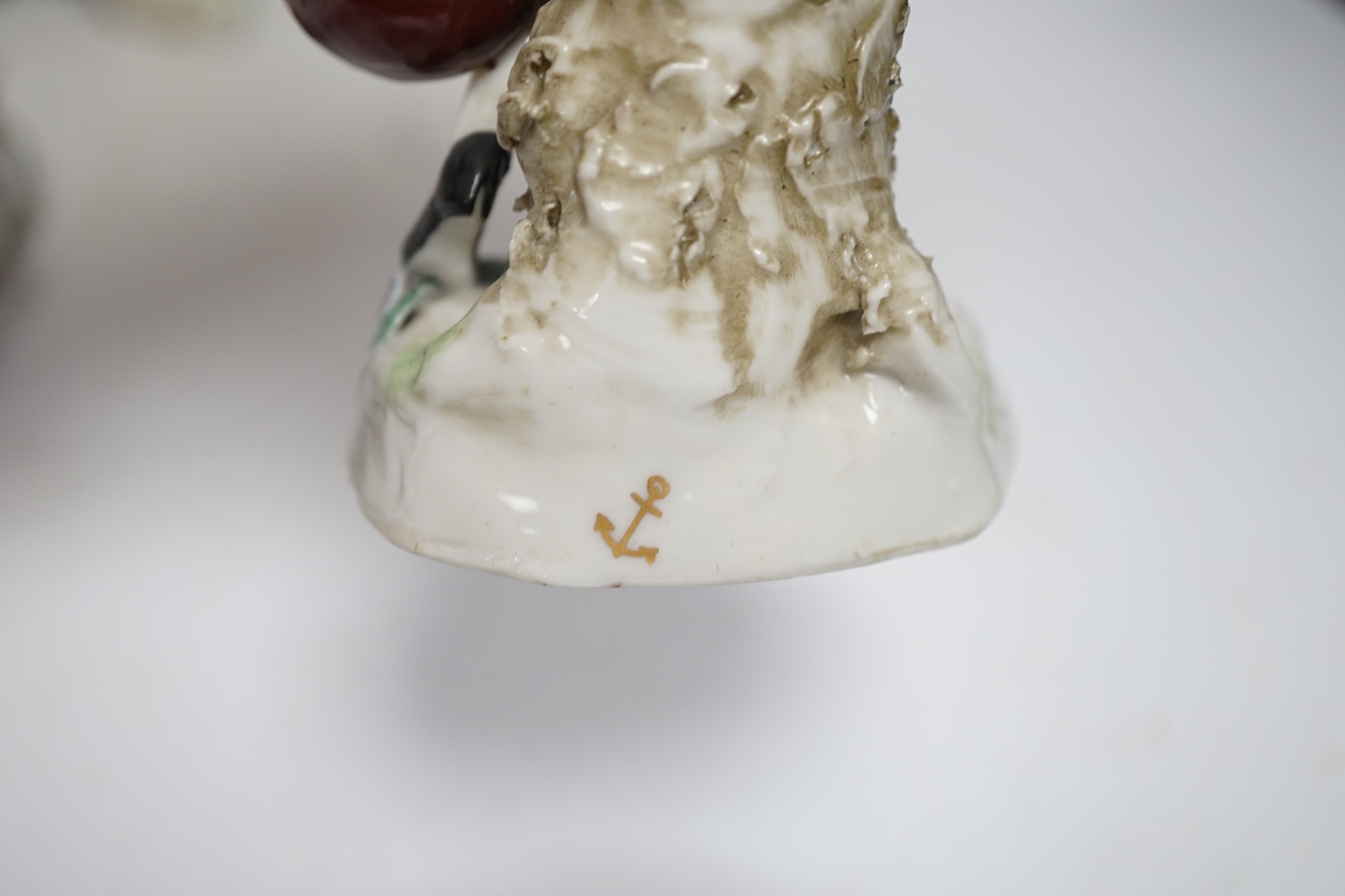A porcelain shell-shaped centrepiece, a Dresden pill box, a pair of taper holders and a porcelain figure, tallest 21cm